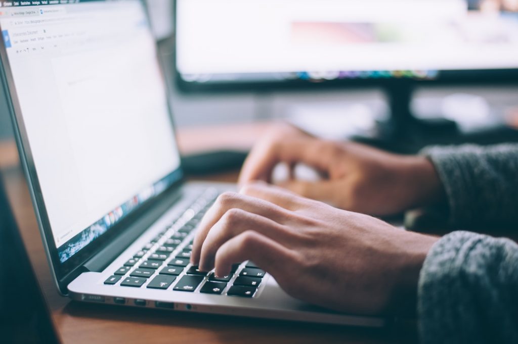 man typing on his laptop